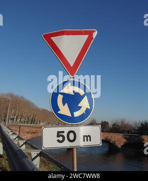 Cartelli normativi, segnaletica stradale per la consegna o per la resa e la rotatoria Foto Stock