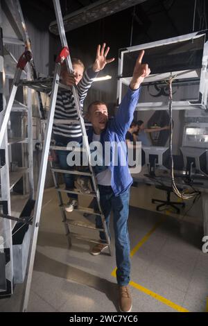 Presteen ragazzo con padre che tiene fuori le mani nella stanza di ricerca Foto Stock