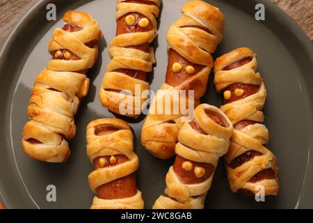 Carine mummie di salsiccia sul piatto, primo piano. Cibo per la festa di Halloween Foto Stock