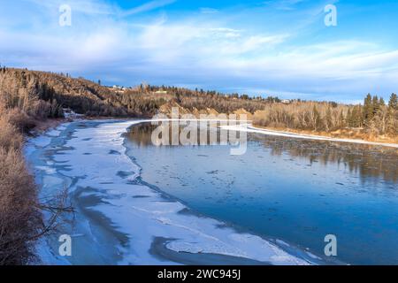 Il fiume North Saskatchewan si piega all'inizio dell'inverno con l'acqua del fiume ghiacciata lungo la riva del fiume Foto Stock