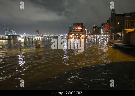 Amburgo, Germania. 15 gennaio 2024. L'acqua dell'Elba viene spinta sul mercato ittico di Amburgo durante un'ondata di tempesta. Lunedì mattina, l'ondata di tempesta ha spinto ancora una volta molta acqua a riva sulla costa del Mare del Nord e nei fiumi Elba e Weser. Ad Amburgo, il mercato del pesce e il Große Elbstraße erano completamente sott'acqua. Secondo la Federal Maritime and Hydrographic Agency (BSH), l'acqua al St. La sagoma di Pauli era salita a circa 2,30 metri sopra l'acqua media poco prima delle 7,00 del mattino. Credito: Bodo Marks/dpa/Alamy Live News Foto Stock