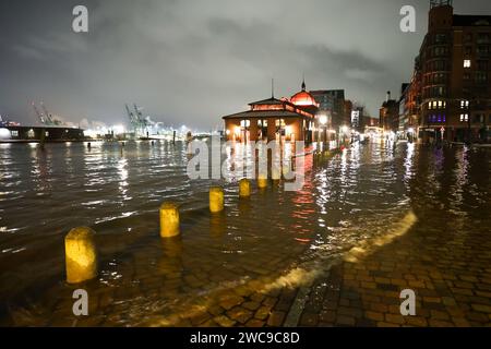 Amburgo, Germania. 15 gennaio 2024. L'acqua dell'Elba viene spinta sul mercato ittico di Amburgo durante un'ondata di tempesta. Lunedì mattina, l'ondata di tempesta ha spinto ancora una volta molta acqua a riva sulla costa del Mare del Nord e nei fiumi Elba e Weser. Ad Amburgo, il mercato del pesce e il Große Elbstraße erano completamente sott'acqua. Secondo la Federal Maritime and Hydrographic Agency (BSH), l'acqua al St. La sagoma di Pauli era salita a circa 2,30 metri sopra l'acqua media poco prima delle 7,00 del mattino. Credito: Bodo Marks/dpa/Alamy Live News Foto Stock