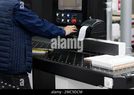 Etichette per la spedizione di codici a barre per l'operatore in fabbrica. Stampante termica di etichette per la spedizione di codici a barre presso la fabbrica di mobili. Messa a fuoco selettiva. Foto Stock