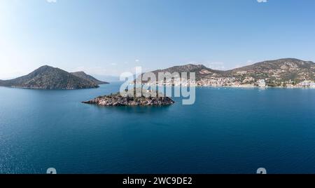 Grecia, Tolo vicino a Nafplio, Argorida, Peloponneso. Vista panoramica aerea con drone del villaggio, piccola isola, barca ormeggiata al porto, mare, cielo blu. Spazio Foto Stock