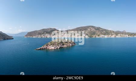 Tolo vicino a Nafplio, Argorida, Peloponneso, Grecia. Vista panoramica aerea con drone del villaggio, piccola isola, barca ormeggiata al porto, mare, cielo blu. Spazio Foto Stock