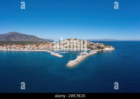 Porto di Paralio Astros, Arcadia, Peloponneso, Grecia. Vista panoramica aerea con drone della città, barca ormeggiata nel porto, acqua di mare ondulata, cielo blu. Foto Stock