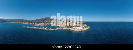 Porto di Paralio Astros, Arcadia, Peloponneso, Grecia. Vista panoramica aerea con drone della città, frangiflutti, barca ormeggiata, acqua di mare, cielo blu. Banner Foto Stock