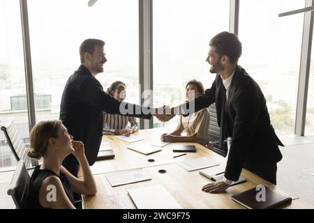 Uomini d'affari felici e di successo che celebrano la cooperazione e l'avvio di progetti di successo Foto Stock
