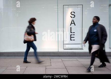 Gli acquirenti sfocano un negozio generico le cui vendite di gennaio sono ora in Victoria Street a Westminster, il 12 gennaio 2024, a Londra, in Inghilterra. Foto Stock