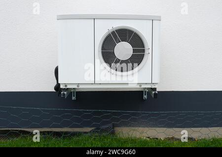 Pompa di calore di fronte alla facciata di una casa Foto Stock