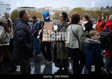 18 novembre 2023: Una donna solitaria distribuisce volantini fuori dal Sea Life London Aquarium incoraggiando il pubblico a boicottare tutti gli acquari per motivi di crudeltà animale. Foto Stock