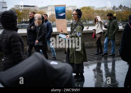 18 novembre 2023: Una donna solitaria distribuisce volantini fuori dal Sea Life London Aquarium incoraggiando il pubblico a boicottare tutti gli acquari per motivi di crudeltà animale. Foto Stock