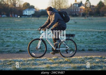 Wimbledon London, Regno Unito. 15 gennaio 2024. . Un ciclista che corre in una fredda mattinata attraverso Wimbledon Common, a sud-ovest di Londra, coperto di fitte gelate..il Met Office ha emesso un allarme meteo di quattro giorni per la neve e il ghiaccio, mentre si prevede che le temperature si abbassino. Crediti: amer ghazzal/Alamy Live News Foto Stock