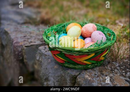 Osterbrauch, Dekoration, gefärbte Eier in verschiedenen Farben liegen im Osternest draußen im Garten Osterbrauch *** l'usanza pasquale, la decorazione, le uova colorate in diversi colori giacciono nel nido pasquale all'esterno nel giardino usanza pasquale Foto Stock