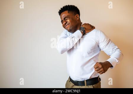 Ritratto di un giovane uomo d'affari che sta soffrendo alla schiena. Spazio di copia sull'immagine per il testo o l'annuncio pubblicitario. Foto Stock