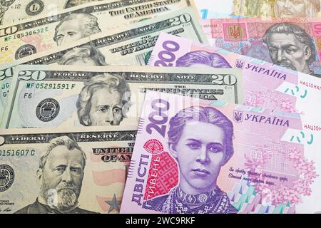 Primo piano su una pila di dollari americani e hryvnia Ucraina. Foto Stock