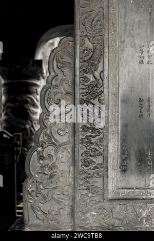 Città di Hue, Vietnam, 19 marzo 2015: Intricato drago nelle nuvole intagliate sull'antica stele di pietra presso il sito storico della tomba di Khai Dinh, Vietnam Foto Stock