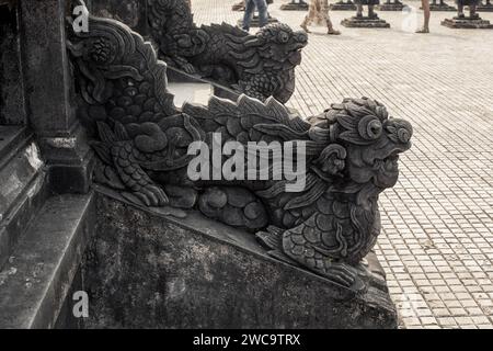 Scultura di drago in pietra intagliata che adorna la scalinata presso la storica tomba di Khai Dinh nella città imperiale di Hue, Vietnam Foto Stock