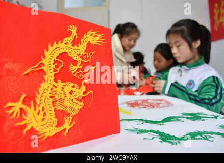 Handan, Cina. 15 gennaio 2024. Gli studenti stanno creando opere tagliate in carta a tema ''anno del drago'' a Handan, provincia di Hebei, Cina, il 13 gennaio 2024. (Foto di Costfoto/NurPhoto) credito: NurPhoto SRL/Alamy Live News Foto Stock