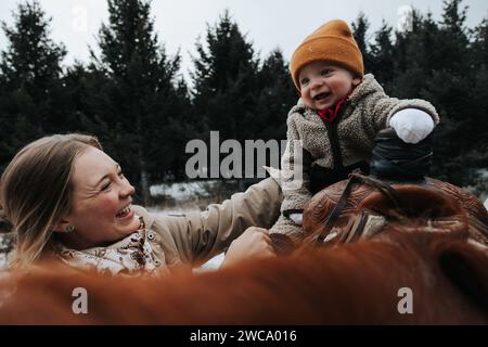 La mamma tiene il bambino in un'avventura a cavallo Foto Stock
