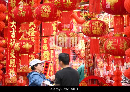 Nanning, Cina. 15 gennaio 2024. La gente sta comprando lanterne e altri ornamenti mascotte con elementi di drago in una tradizionale strada cinese per lo shopping di Capodanno a Nanning, in Cina, il 14 gennaio 2024. (Foto di Costfoto/NurPhoto) credito: NurPhoto SRL/Alamy Live News Foto Stock
