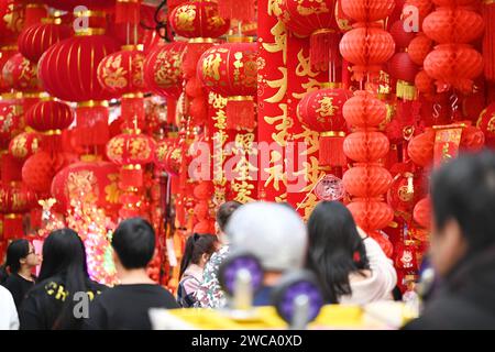 Nanning, Cina. 15 gennaio 2024. La gente sta comprando lanterne e altri ornamenti mascotte con elementi di drago in una tradizionale strada cinese per lo shopping di Capodanno a Nanning, in Cina, il 14 gennaio 2024. (Foto di Costfoto/NurPhoto) credito: NurPhoto SRL/Alamy Live News Foto Stock