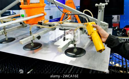 Un lavoratore sta premendo un pulsante di controllo del piano d'acciaio per accedere al processo di taglio dell'acciaio nella fabbrica industriale Foto Stock