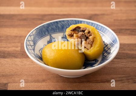 Panino di patate dolci fatto in casa con carne di maiale macinata, funghi e farciture di bambù tritate all'interno in una ciotola su fondo di legno. Foto Stock