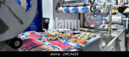Linea automatica per la produzione di alimenti su macchine a nastro trasportatore in fabbrica, produzione alimentare industriale Foto Stock