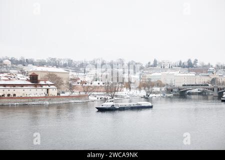 Neve a Praga, rare condizioni invernali fredde. Barca Praga in Repubblica Ceca, tempo innevato con edifici. Foto Stock