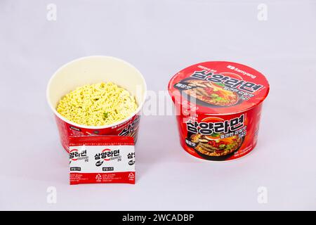 Ulsan, Corea del Sud - 14 gennaio 2024: Una confezione di ramen umami piccante di Samyang in una tazza rotonda, aperta per rivelare i noodle essiccati all'interno, con il Foto Stock