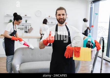 Ritratto di un uomo caucasico barbuto che si occupa della pulizia con secchio di detersivi Foto Stock
