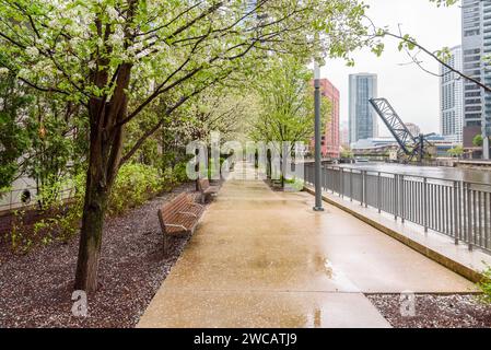 Sentiero alberato deserto lungo un fiume in un quartiere del centro in un giorno di pioggia primaverile Foto Stock