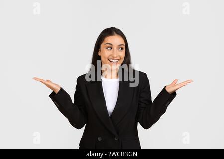 Felice soddisfatta donna d'affari caucasica in tuta reagire alle grandi notizie, alzare la mano, rallegrarsi e sorridere Foto Stock