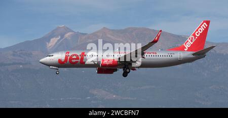 Tenerife, Spagna 13 gennaio 2024. Boeing 737-86N Jet2 Airlines vola nel cielo blu. Atterraggio all'aeroporto di Tenerife. Il vulcano El Teide nel backgrou Foto Stock
