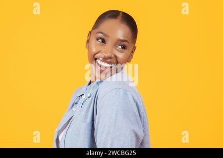 Ritratto di una bella donna nera che sorride a guardare da parte, studio Foto Stock