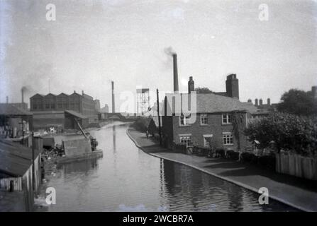 1941, storico, una vista da quest'epoca del Canale Bridgewater a Leigh, che mostra gli edifici lungo il fiume con diversi camini fumanti. Aperto nel 1761, il corso d'acqua fu costruito dal III duca di Bridgewater per trasportare carbone dalle sue miniere di Worsley a Manchester e collegare Runcorn, Manchester e Leigh nel nord-ovest dell'Inghilterra, Regno Unito. Foto Stock