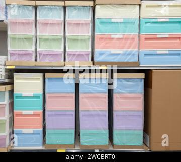Cassetti in plastica colorati su scaffali di un grande magazzino. Foto Stock