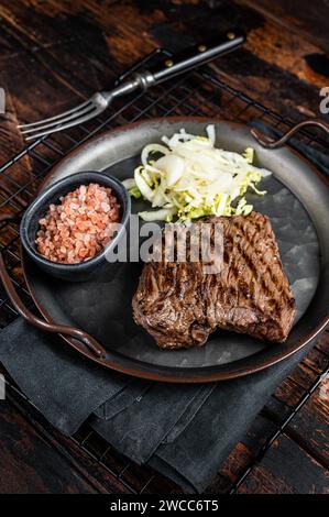 Bistecca di cervo con sale marino e insalata. Sfondo di legno. Vista dall'alto. Foto Stock