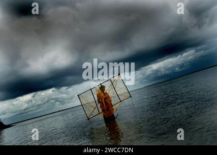 Donne che raccolgono semi di gamberi dal fiume salino del delta del Sundarban. La povertà prevale tra gli abitanti del villaggio che circa 60.000 famiglie vanno nelle acque alte del torace dei fiumi di Sundarbans regolarmente alla ricerca di semi di gamberi (Bagda), dove spesso cadono preda di morsi di squali e prendono malattie della pelle. La vita nei Sundarbans, il delta più grande del mondo, è incentrata sulla lotta per la sopravvivenza, sia che si tratti di cibo, rifugio o di fuga dai mangiatori di uomini. Gosaba, Sundarban, Bengala Occidentale, India. Foto Stock