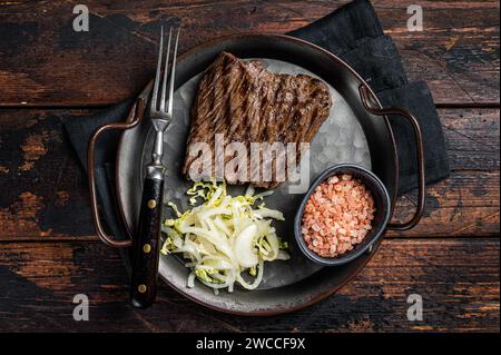 Bistecca di cervo con sale marino e insalata. Sfondo di legno. Vista dall'alto. Foto Stock