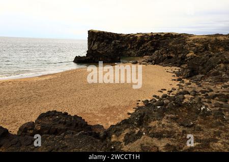 Skarðsvík è una piccola e affascinante spiaggia con enormi formazioni rocciose basaltiche e una spiaggia di sabbia dorata situata nel Parco Nazionale di Snæfellsjökull Foto Stock