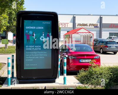 17.09.2023, Mindelheim im Allgäu, Ladesäule für e-Autos an einem Supermarktparkplatz, dem Allgäu-Center. Die firma NUMBAT bietet Schnelladesäulen mit Werbemöglichkeit auf dem großen display. IM inneren der Ladesäule arbeitet ein Großer inegrierter Batteriespeicher. Diese können fast überall auch ohne hohe Kapazität des vorhandenen Stromnetzes betrieben werden, weil SIE mit einer Anschlussleistung ab 20 kilowatt befüllt werden können. Der Speicher ergänzt die Anschlussleistung und kann ein Elektroauto in weniger als 20 Minuten zu 80 Prozent carico. Die Batterien werden in Asien bei Samsung und L. Foto Stock