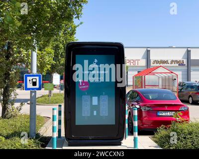 17.09.2023, Mindelheim im Allgäu, Ladesäule für e-Autos an einem Supermarktparkplatz, dem Allgäu-Center. Die firma NUMBAT bietet Schnelladesäulen mit Werbemöglichkeit auf dem großen display. IM inneren der Ladesäule arbeitet ein Großer inegrierter Batteriespeicher. Diese können fast überall auch ohne hohe Kapazität des vorhandenen Stromnetzes betrieben werden, weil SIE mit einer Anschlussleistung ab 20 kilowatt befüllt werden können. Der Speicher ergänzt die Anschlussleistung und kann ein Elektroauto in weniger als 20 Minuten zu 80 Prozent carico. Die Batterien werden in Asien bei Samsung und L. Foto Stock