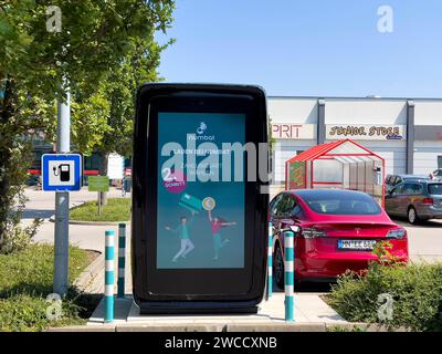 17.09.2023, Mindelheim im Allgäu, Ladesäule für e-Autos an einem Supermarktparkplatz, dem Allgäu-Center. Die firma NUMBAT bietet Schnelladesäulen mit Werbemöglichkeit auf dem großen display. IM inneren der Ladesäule arbeitet ein Großer inegrierter Batteriespeicher. Diese können fast überall auch ohne hohe Kapazität des vorhandenen Stromnetzes betrieben werden, weil SIE mit einer Anschlussleistung ab 20 kilowatt befüllt werden können. Der Speicher ergänzt die Anschlussleistung und kann ein Elektroauto in weniger als 20 Minuten zu 80 Prozent carico. Die Batterien werden in Asien bei Samsung und L. Foto Stock