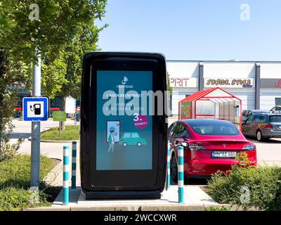 17.09.2023, Mindelheim im Allgäu, Ladesäule für e-Autos an einem Supermarktparkplatz, dem Allgäu-Center. Die firma NUMBAT bietet Schnelladesäulen mit Werbemöglichkeit auf dem großen display. IM inneren der Ladesäule arbeitet ein Großer inegrierter Batteriespeicher. Diese können fast überall auch ohne hohe Kapazität des vorhandenen Stromnetzes betrieben werden, weil SIE mit einer Anschlussleistung ab 20 kilowatt befüllt werden können. Der Speicher ergänzt die Anschlussleistung und kann ein Elektroauto in weniger als 20 Minuten zu 80 Prozent carico. Die Batterien werden in Asien bei Samsung und L. Foto Stock