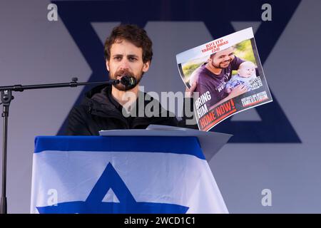 Trafalgar Square, Londra, Regno Unito. 14 gennaio 2024. Eylon Keshet, cugino di Yarden Bibas, rapito da Hamas insieme alla moglie Shiri, figli di 4 anni, Ariel e poi bambino di 9 mesi, Kfir, il 7 ottobre 2023, parla a migliaia di persone che hanno partecipato alla manifestazione Stand with Israel tenutasi a Londra per celebrare 100 giorni da quando gli ostaggi sono stati catturati in seguito all'attacco terroristico di Hamas su Israele. Foto di Amanda Rose/Alamy Live News Foto Stock