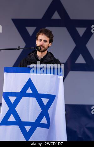 Trafalgar Square, Londra, Regno Unito. 14 gennaio 2024. Eylon Keshet, cugino di Yarden Bibas, rapito da Hamas insieme alla moglie Shiri, figli di 4 anni, Ariel e poi bambino di 9 mesi, Kfir, il 7 ottobre 2023, parla a migliaia di persone che hanno partecipato alla manifestazione Stand with Israel tenutasi a Londra per celebrare 100 giorni da quando gli ostaggi sono stati catturati in seguito all'attacco terroristico di Hamas su Israele. Foto di Amanda Rose/Alamy Live News Foto Stock