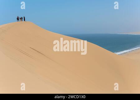 SANDWHICH HARBOR, 2023 novembre 08: I turisti godono di una vista aerea della costa desertica di Nuakluft dall'enorme cima di una duna, scattata con una luce brillante in tarda primavera l'8 novembre 202 Foto Stock