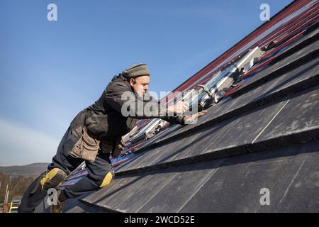 Chiodatura di nuove piastrelle sul tetto della casa di ricambio, Llanfoist, Galles, Regno Unito Foto Stock
